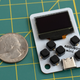 The Arduboy Mini compared in size to a US quarter.